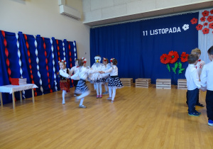 19 Dzieci w kółkach tańczą wokół dzieci będących symbolami narodowymi