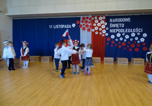 20 Dzieci w kółkach tańczą wokół dzieci będących symbolami narodowymi