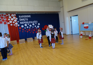 21 Dzieci w kółkach tańczą wokół dzieci będących symbolami narodowymi