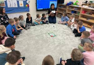 Nauczycielka czyta fakty o dinozaurach