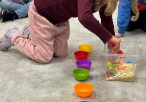 Dziewczynka wyjmuje dinozaury