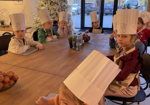 Dzieci siedzą przy stole.