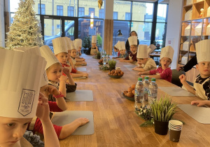 Dzieci siedzą przy stole.