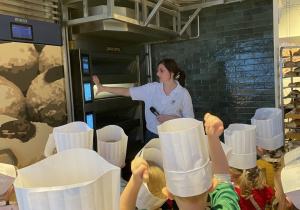 Dzieci oglądają piec do wypieku bułek.