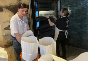 Pani wstawia bułki do pieca.