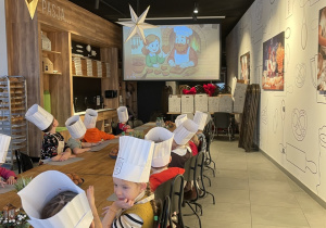 Dzieci oglądają bajkę o tym jak powstały pierniczki.