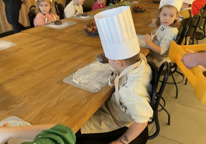 Dzieci biorą udział w warsztatach pieczenia pierników.