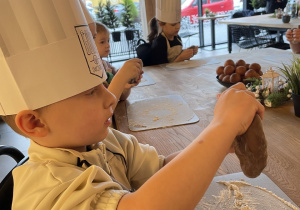 Dzieci biorą udział w warsztatach pieczenia pierników.