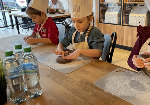 Dzieci biorą udział w warsztatach pieczenia pierników.