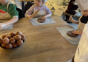 Dzieci biorą udział w warsztatach pieczenia pierników.