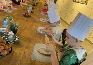 Dzieci biorą udział w warsztatach pieczenia pierników.