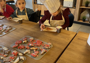 Dzieci jedzą pizzę.