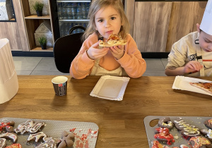 Dzieci jedzą pizzę.