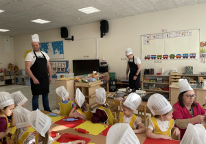 Rodzice przygotowują składniki potrzebna do pieczenia pizzy.