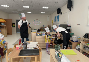 Rodzice wraz z dziećmi przygotowują ciasto.