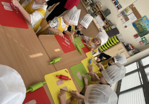 Dzieci kroją szynkę do pizzy.