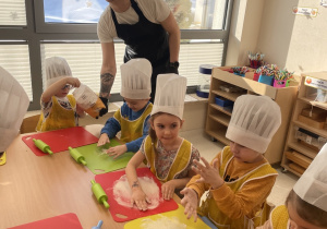 Dzieci sypią podkładki mąką.