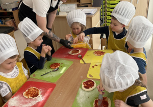 Dzieci wybierają składniki, które położą na swojej pizzy.