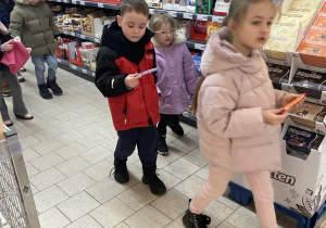 Dzieci udają się do sklepowej kasy.