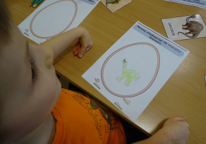 Chłopiec pokazuje rysunek swojego dinozaura.