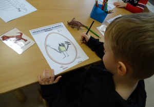 Chłopiec pokazuje rysunek swojego dinozaura.