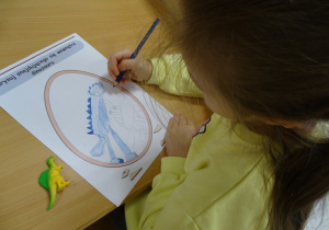 Chłopiec pokazuje rysunek swojego dinozaura.