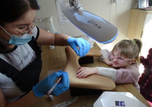 14 Dziewczynka podczas malowania serduszka na paznokciu