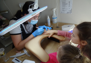 15 Pani kosmetyczka maluje serduszko na paznokciach dziewczynek