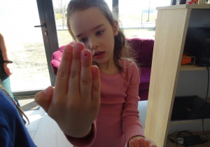 18 Dziewczynka pokazuje serduszko namalowane na paznokciu