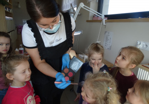 32 Pani kosmetyczka nakłada dziewczynkom róz na policzki