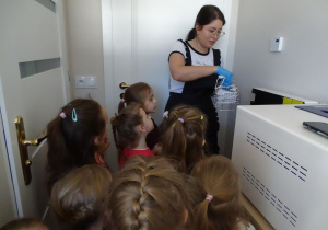 43 Pani kosmetyczka pokazuje urządzenie do sterylizacji narzędzi kosmetycznych