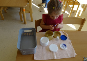 dziewczynka otwiera pojemniki