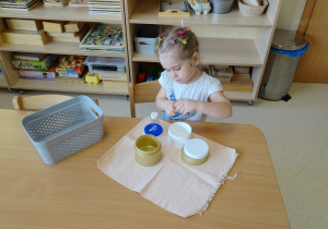 dziewczynka otwiera pojemniki