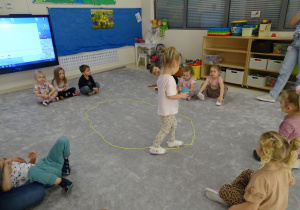 dziecko chodzi po elipsie z kubkiem wody