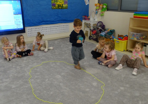 dziecko chodzi po elipsie z kubkiem wody