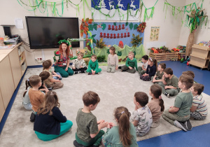 Pani wita dzieci animując pacynką dinozaura