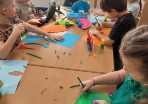 Dzieci wykonują prace plastyczną z talerzyka papierowego