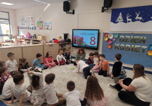 Dzieci wykonują zadania matematyczne na dywanie