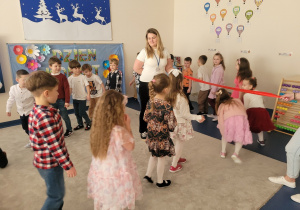 Zabawa w kamienny mosteczek, dzieci przechodzą pod szarfą