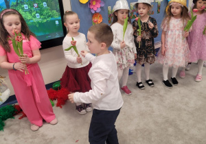 Chłopcy wręczają dziewczynkom upominki