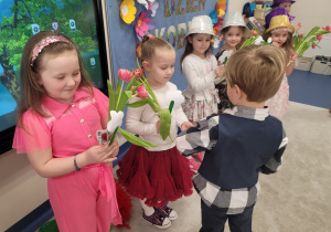 Chłopcy wręczają dziewczynkom upominki