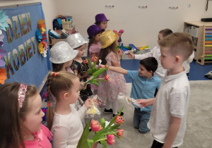 Chłopcy wręczają dziewczynkom upominki