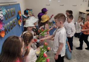 Chłopcy wręczają dziewczynkom upominki