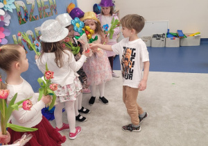 Chłopcy wręczają dziewczynkom upominki