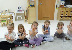 20 Pani pokazuje dzieciom znak matematyczny w postaci obrazka, dzieci pokazują go dłońmi