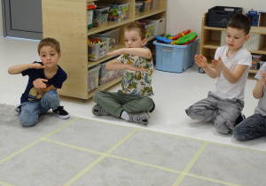 23 Dzieci pokazują za pomocą rąk kolejny znak matematyczny