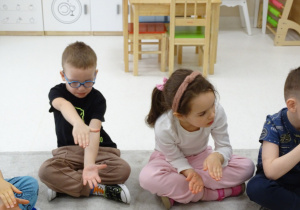 24 Dzieci pokazują za pomocą rąk kolejny znak matematyczny