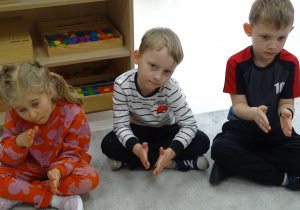 26 Dzieci pokazują za pomocą rąk kolejny znak matematyczny