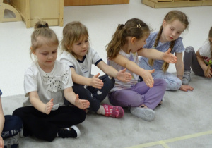 27 Dzieci pokazują za pomocą rąk kolejny znak matematyczny