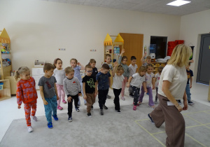 29 Dzieci z panią podczas zabawy muzyczno - ruchowej utrwalającej kierunki w przestrzeni i stronności własnego ciała